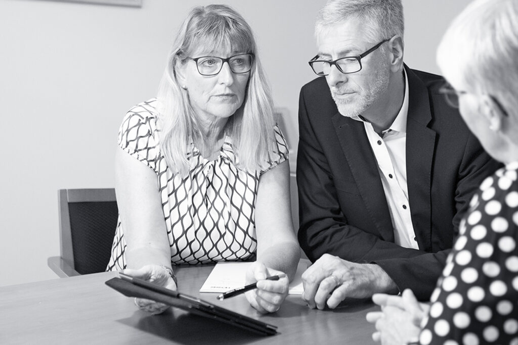 3 Personen im Beratungsgespräch zur finanziellen Bestattungsvorsorge mittels eines Tabletts.